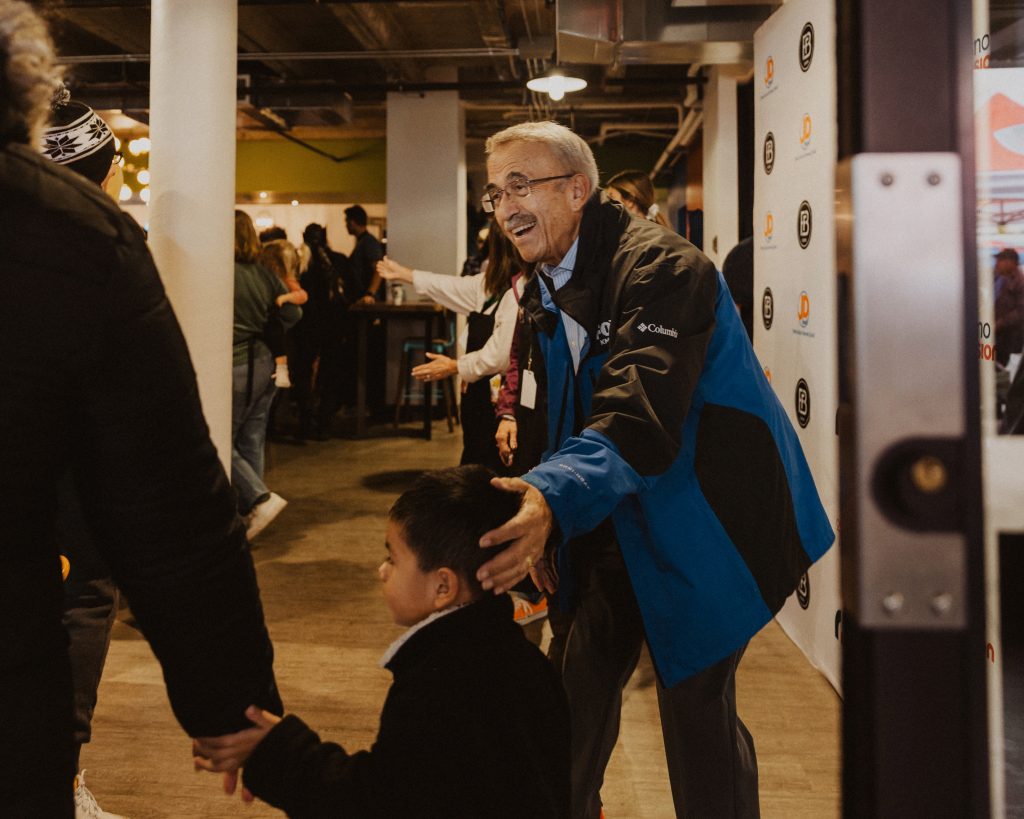A volunteer welcomes a child at One Table