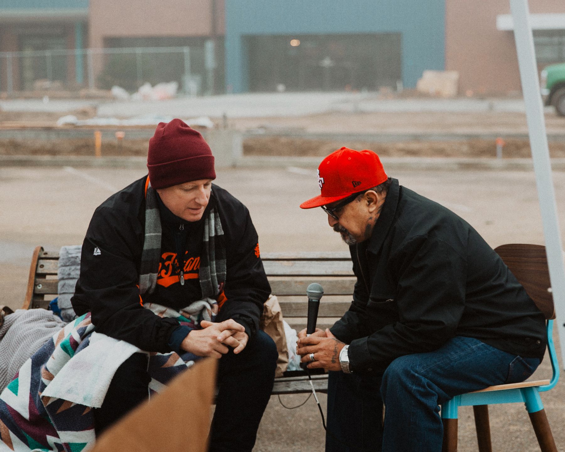 Matt Dildine in conversation with a guest holding a microphone