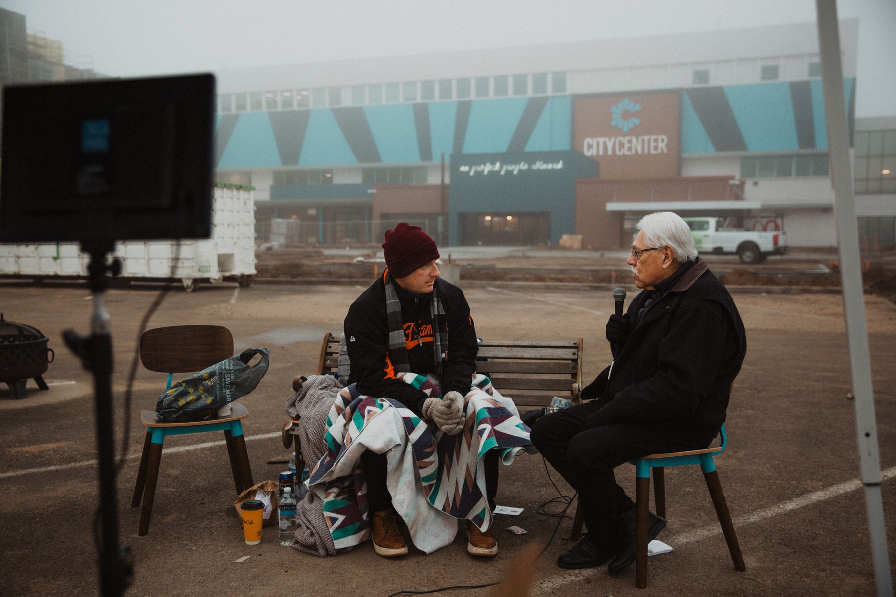 Matt Dildine wrapped in a blanket on the bench during a foggy morning conversation