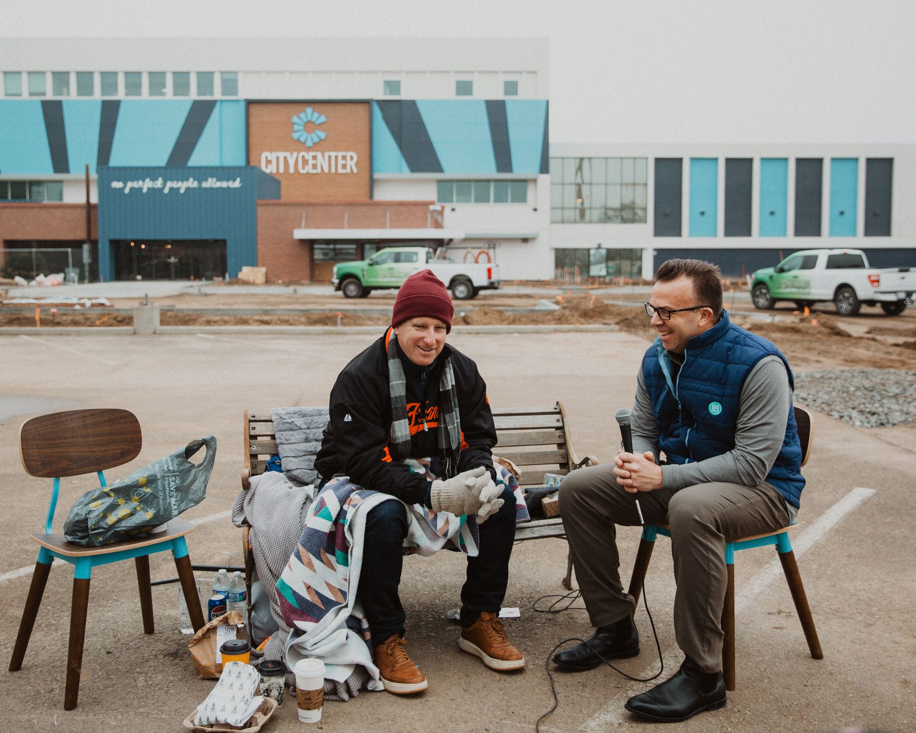 Matt Dildine laughing with a guest on the bench in front of City Center