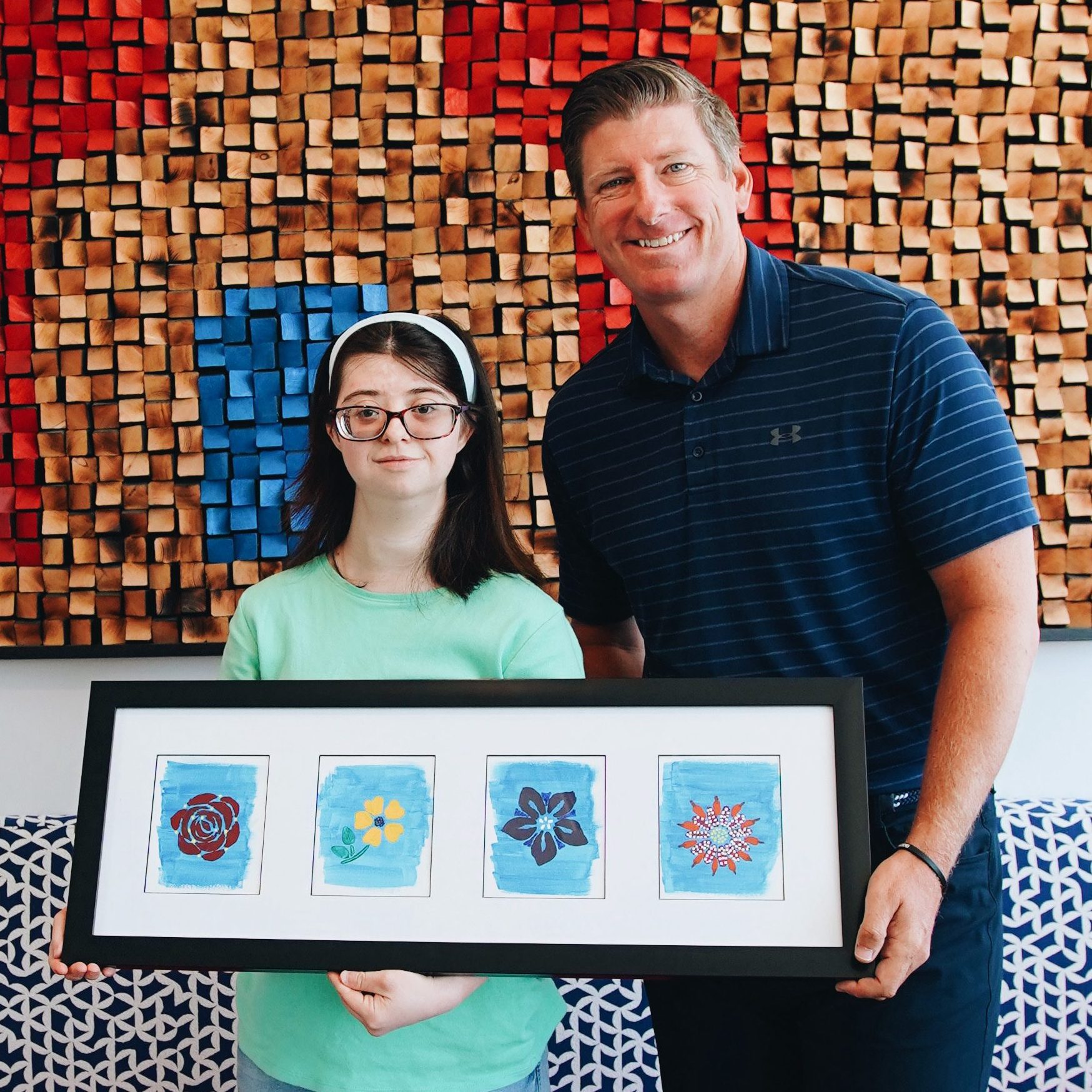 Haley and Matt Dildine, CEO of the Fresno Mission, holding Haley's art work.